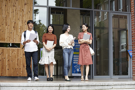 走出教学楼拿着文件的大学生图片