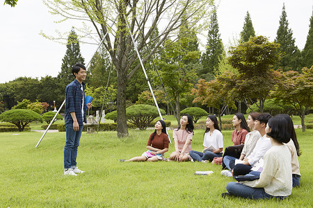 公园草坪上自我介绍的大学生背景图片