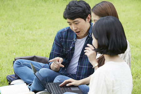 户外看着笔记本电脑讨论学习的青年大学生图片