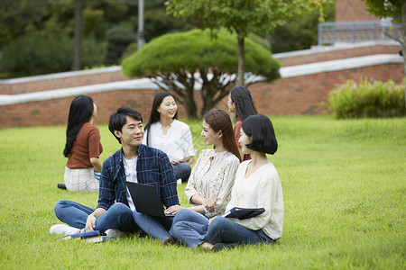 户外草坪上聊天放松的大学生图片