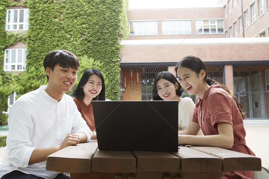 看着笔记本电脑微笑的的大学生图片