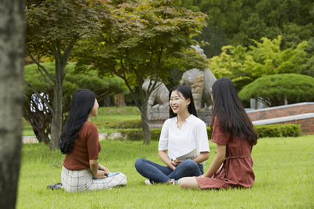 校园草坪上聊天休息的大学生图片