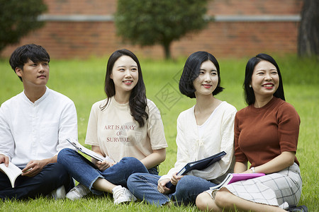 草坪上放松微笑的大学生图片