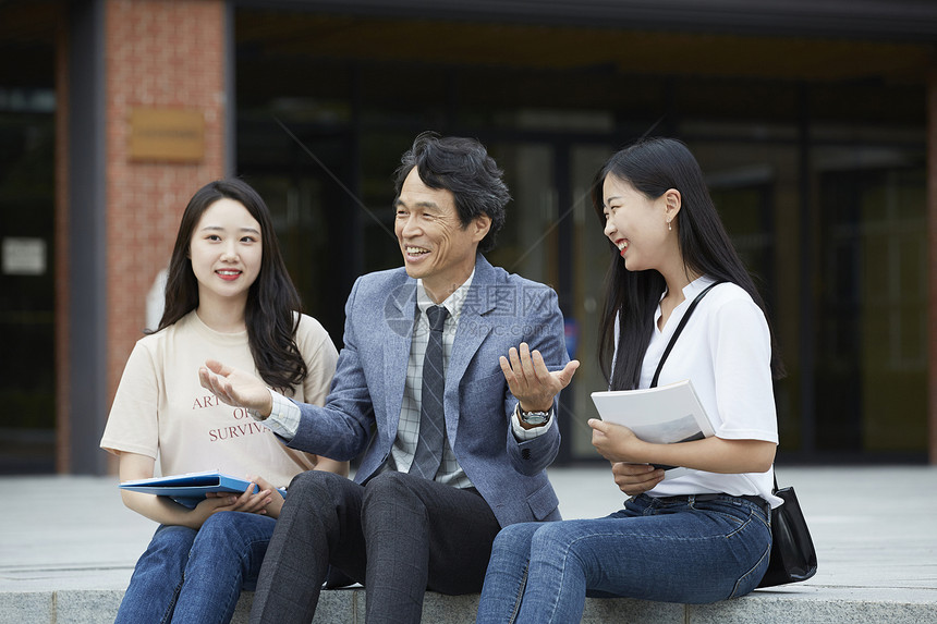 教授和学生们坐在台阶上休息聊天图片