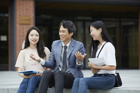 教授和学生们坐在台阶上休息聊天图片