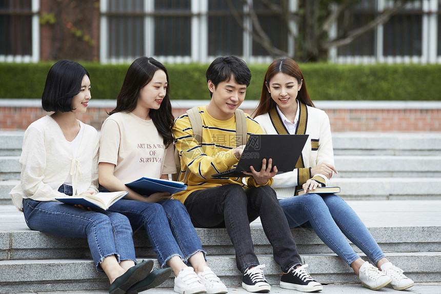 坐在台阶上看电脑的大学生图片