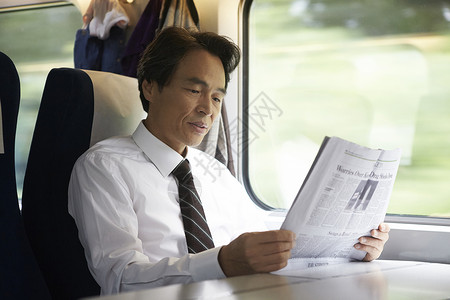 火车上看报纸的成年男性图片