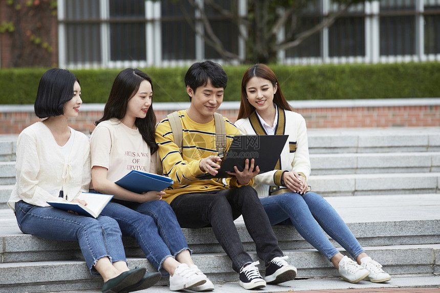 台阶上看着电脑的大学生图片