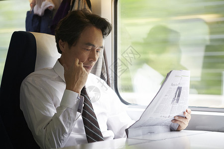 火车上看报纸的成年男子背景图片