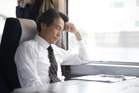 火车上闭眼休息的成年男子图片
