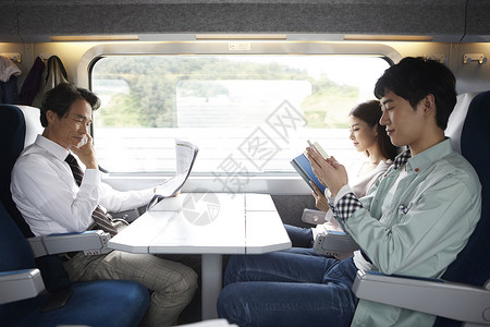 火车上各自忙碌的乘客图片