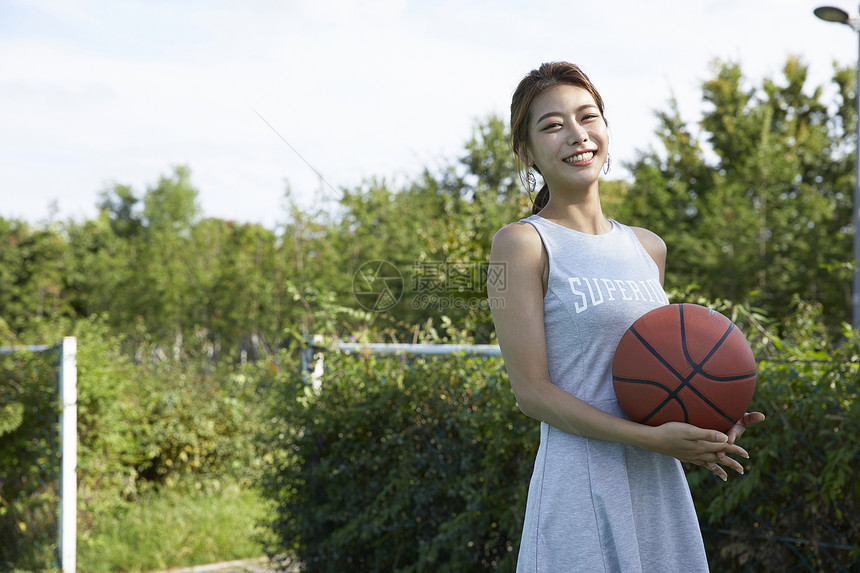 快乐笑年轻女子运动篮球图片