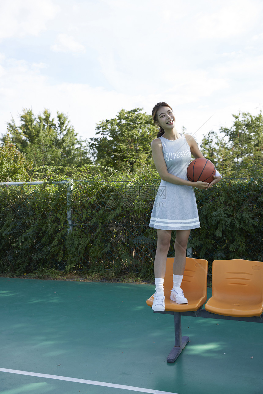 幸福树前视图年轻女子运动篮球图片
