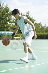 篮球场上的运动男青年运球图片