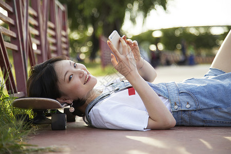 滑板女孩躺着看手机图片