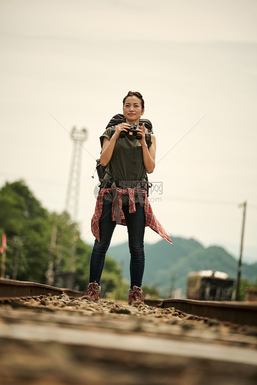 背包客女生在废弃铁路上旅游观光图片