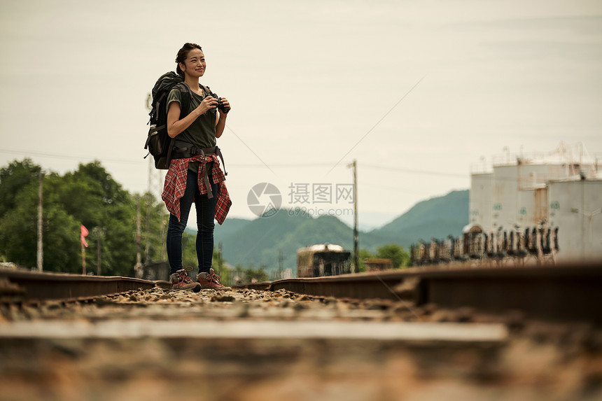 背包客女生在废弃铁路上旅游观光图片