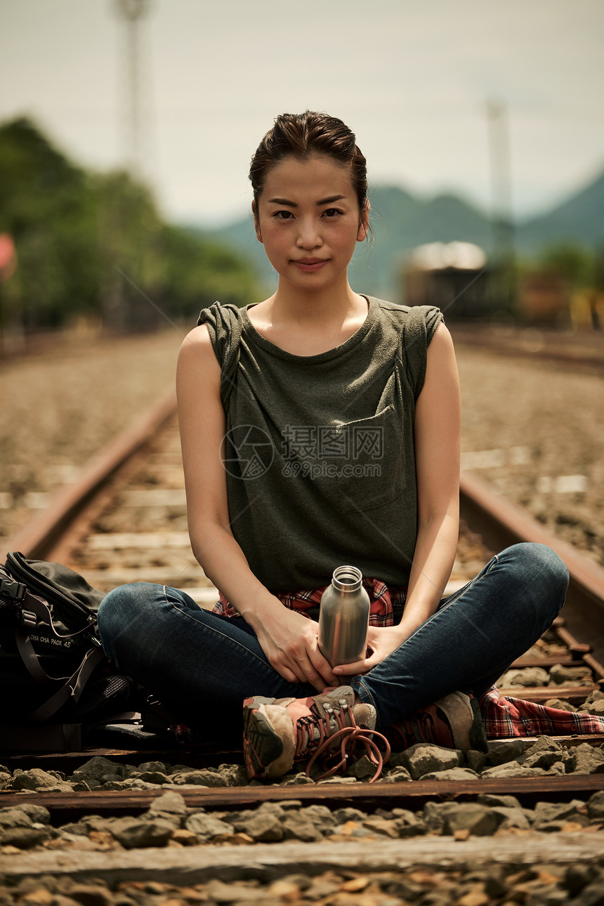 年轻女人在铁轨边休息
图片