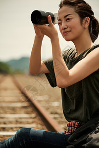 废弃铁轨前的年轻女子拍摄图片