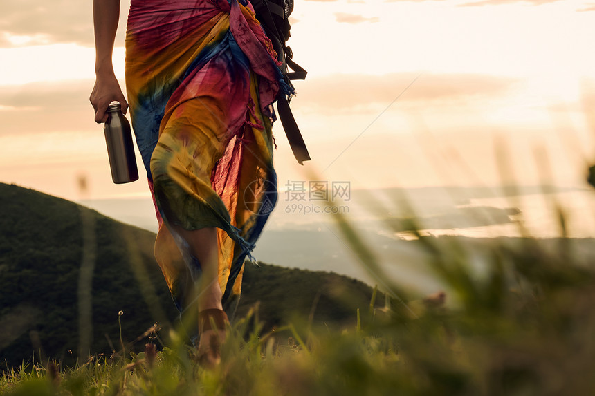夕阳单人日落女人背包客去草地上图片