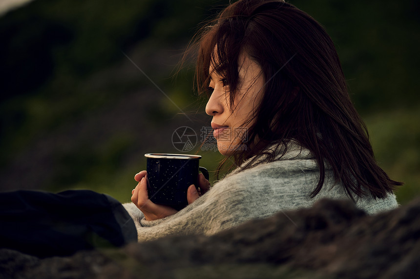 户外手拿杯子喝咖啡的女性图片