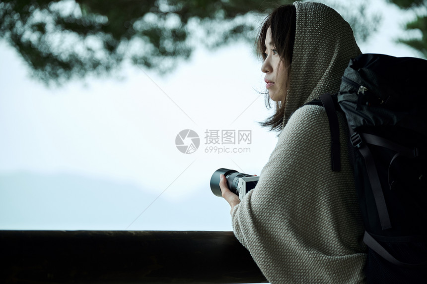 打碎摄影女郎观看妇女背包徒步旅行者湖边画象图片