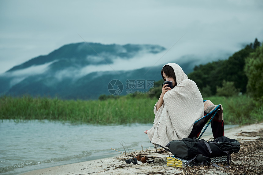 户外旅途爱好女背包客湖边茶时间图片