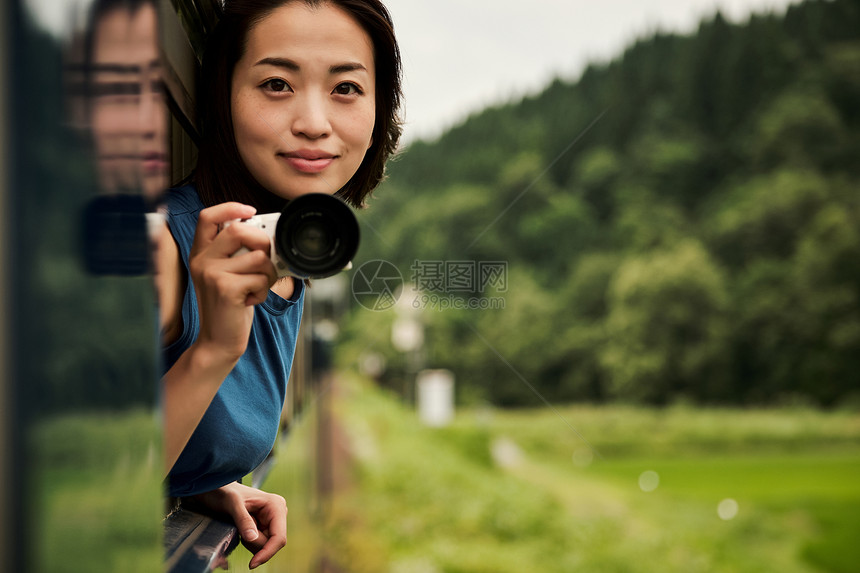 拿着相机的年轻女性图片