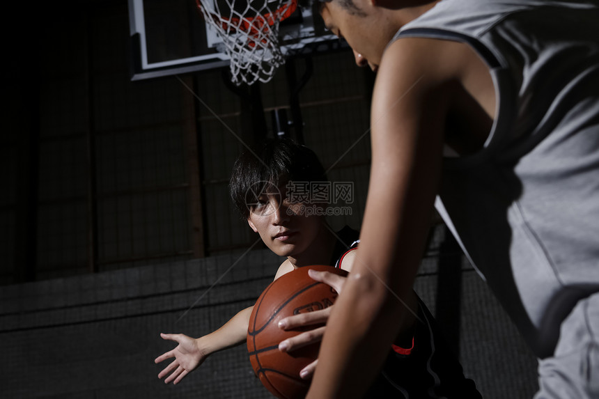 室内篮球馆打篮球的青年男子图片