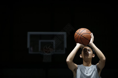 拿着篮球投篮的年轻男性图片