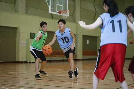 室内体育馆打篮球运球的成年男子图片
