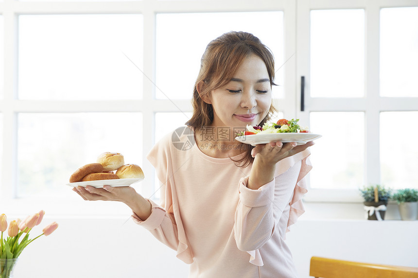 双手拿着餐盘享受的女青年图片