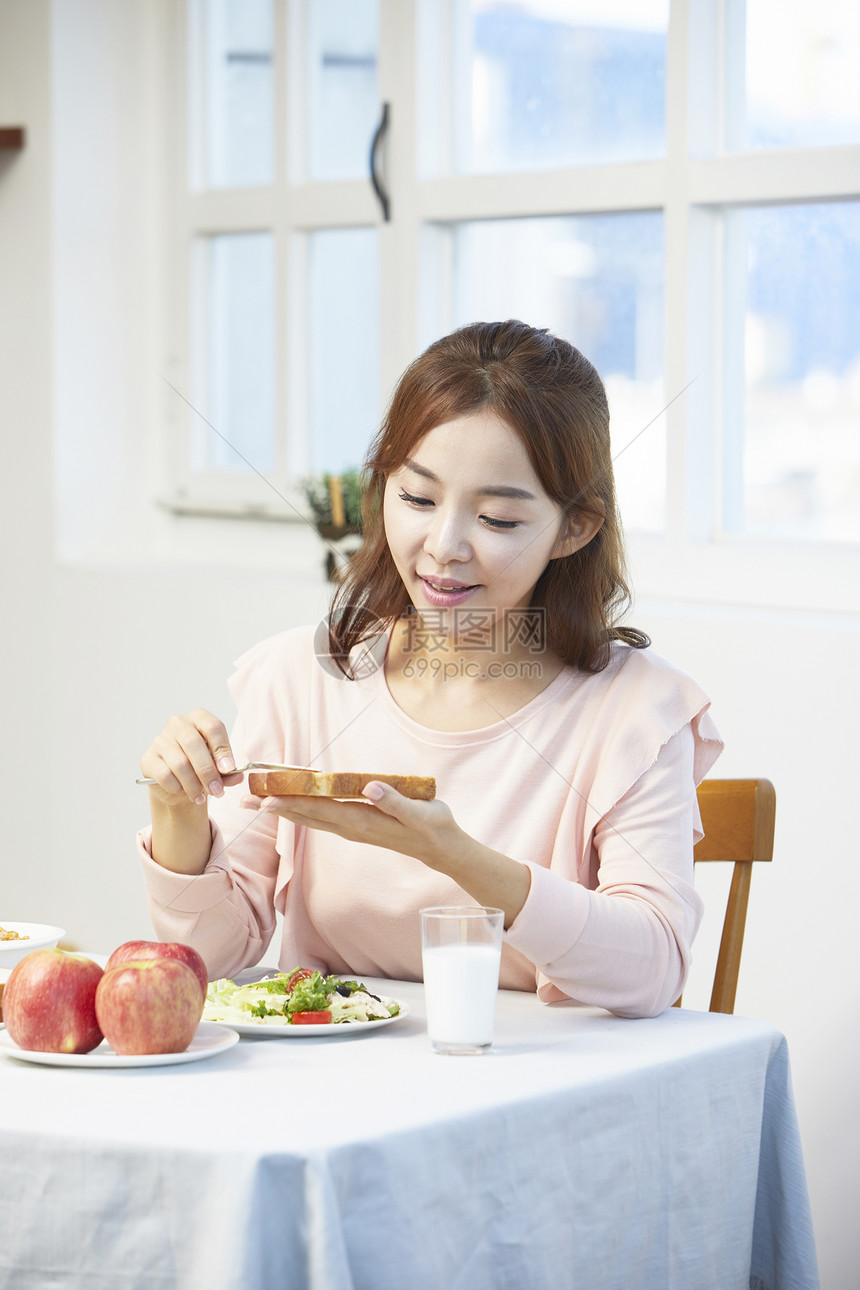 面包上涂抹果酱的女孩图片