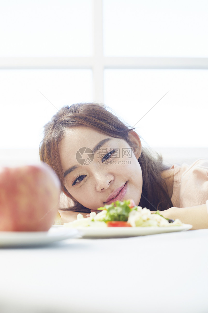 看着食物微笑的女性图片