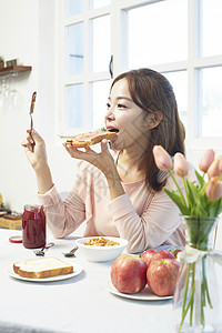 年轻女性开心的吃着果酱土司图片