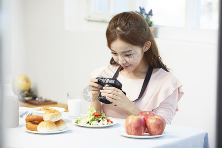 居家女性用照相机拍菜图片