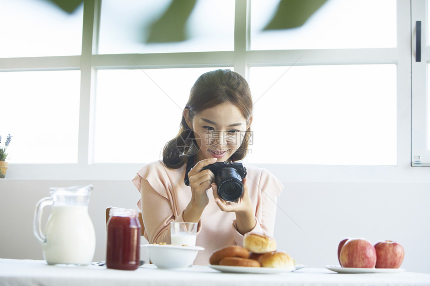 居家女性用照相机拍菜图片