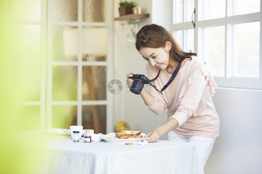 咖啡馆拿着相机拍食物照片女青年图片