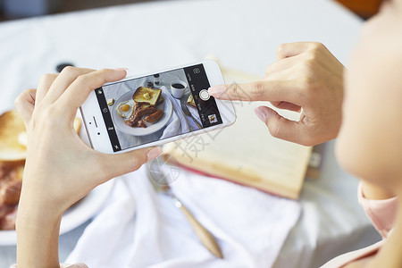 手机拍食物照片的手特写背景图片