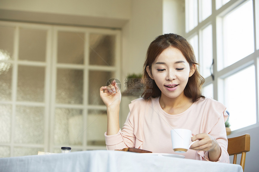 年轻女子居家享用早餐图片