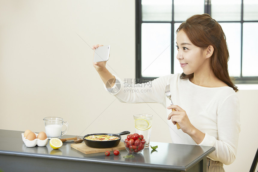 年轻女子居家享用早餐图片