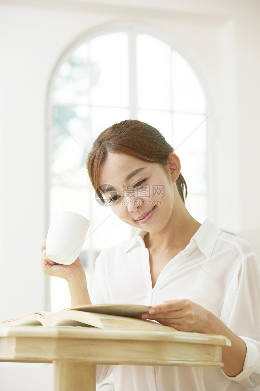 居家阅读喝咖啡的年轻女子图片