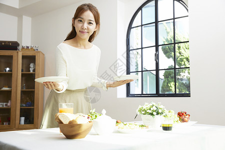 居家布置餐桌的年轻女性图片