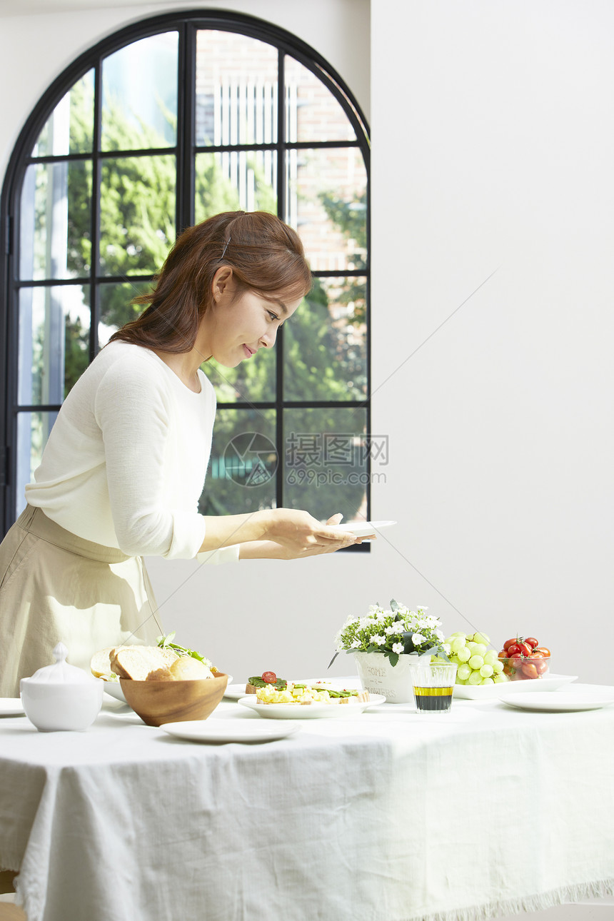 摆放餐具食物的居家女性图片