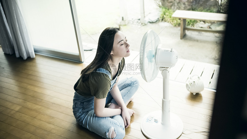 夏天坐着在家吹风扇的妇女图片