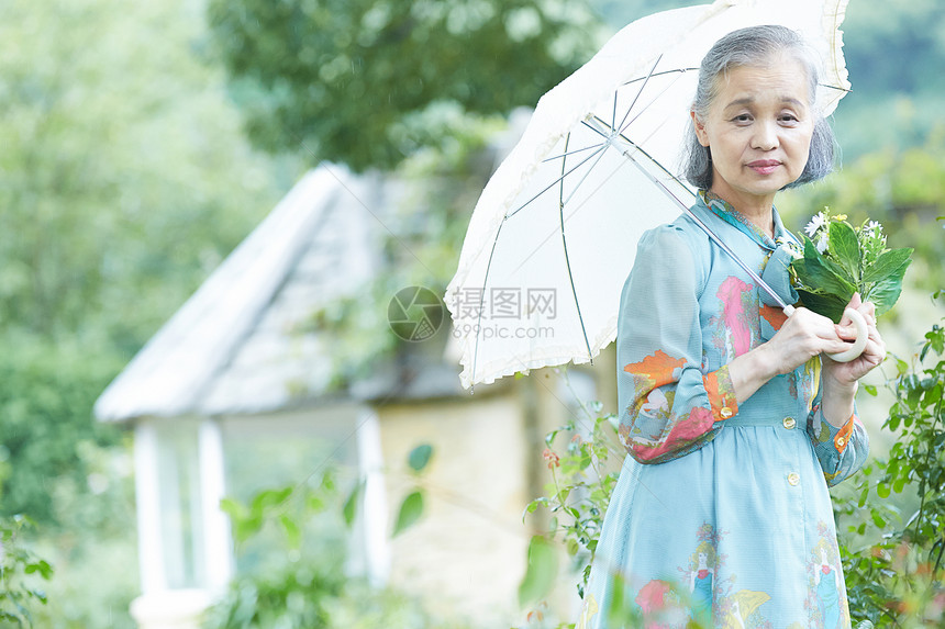 在院子里撑伞的老年阿姨图片