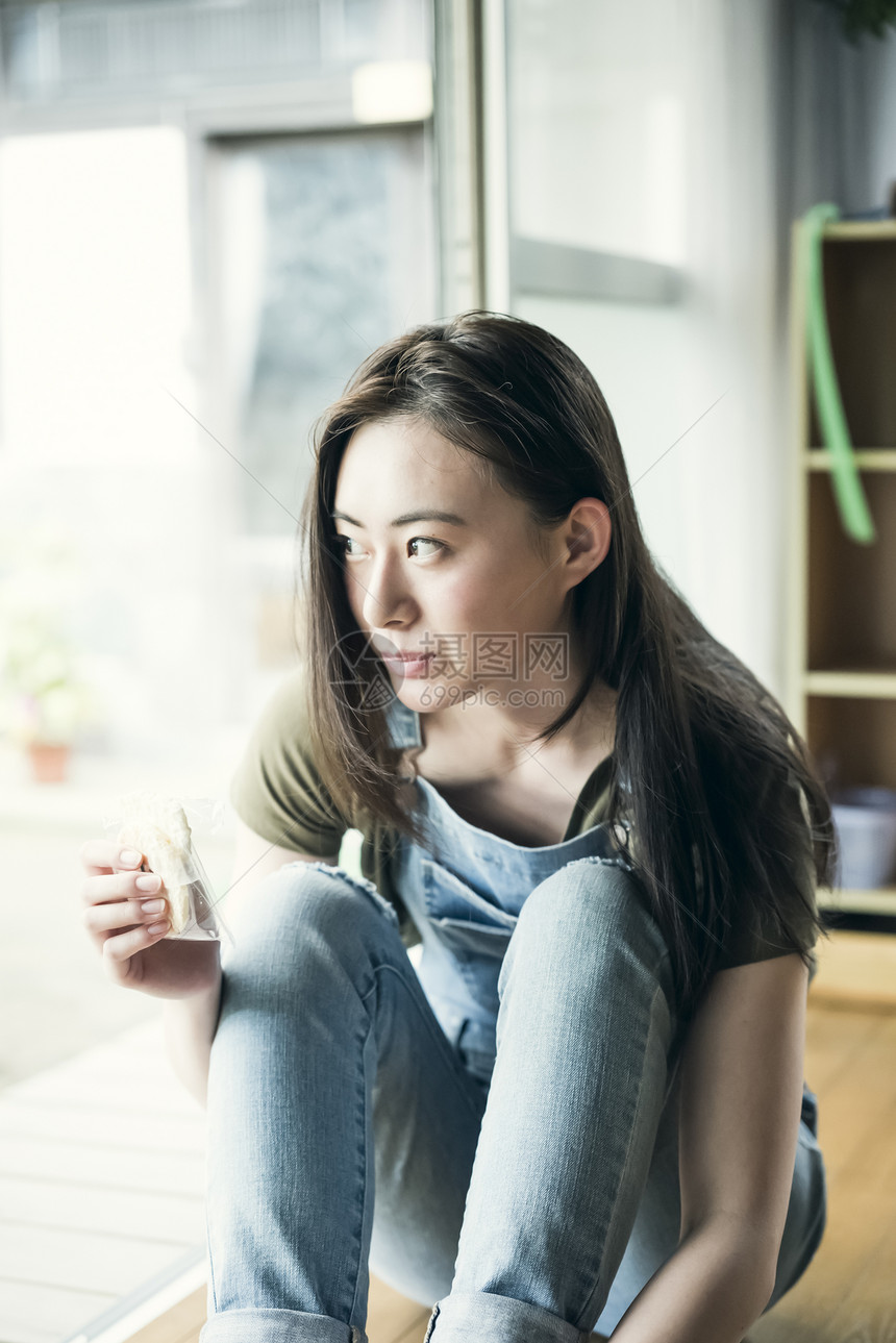 居家吃着零食的年轻女性图片