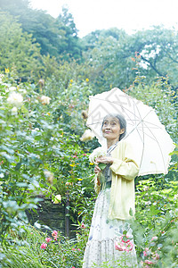 户外庭院打着遮阳伞的女性图片