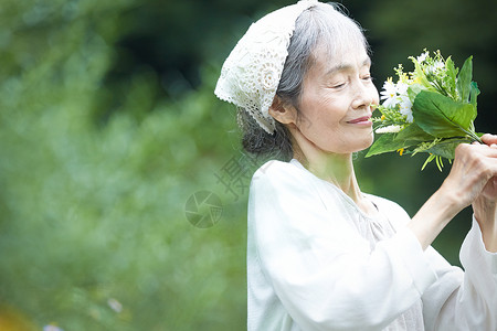 老年妇女在庭院里赏花图片