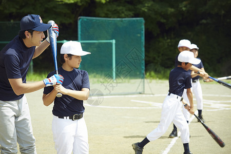 小姑娘上司操场男孩棒球男孩实践的打击画象图片